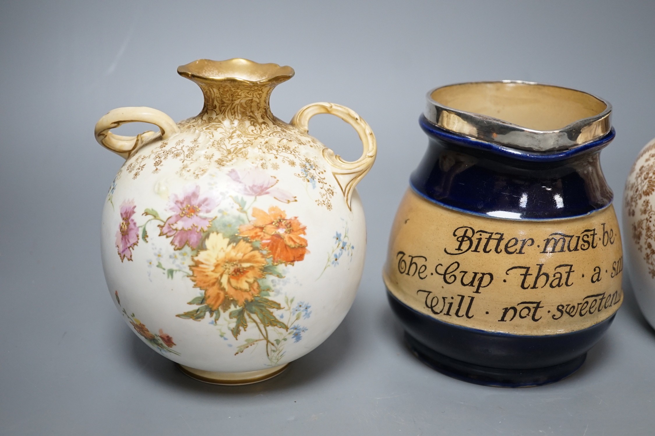 A late 19th / Early 20th century Doulton two handled vase and a Doulton vase and cover both painted with flowers on a blush ivory ground, Doulton Burslem England mark together with a Royal Doulton jug with silver mount a